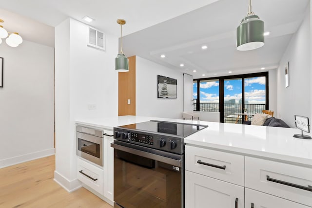 kitchen featuring floor to ceiling windows, hanging light fixtures, black electric range oven, white cabinets, and light wood-type flooring