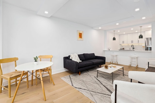 living room featuring light hardwood / wood-style flooring and sink