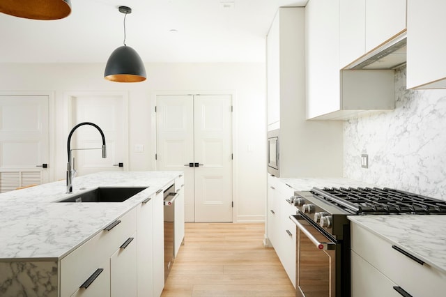 kitchen featuring white cabinetry, sink, pendant lighting, and appliances with stainless steel finishes