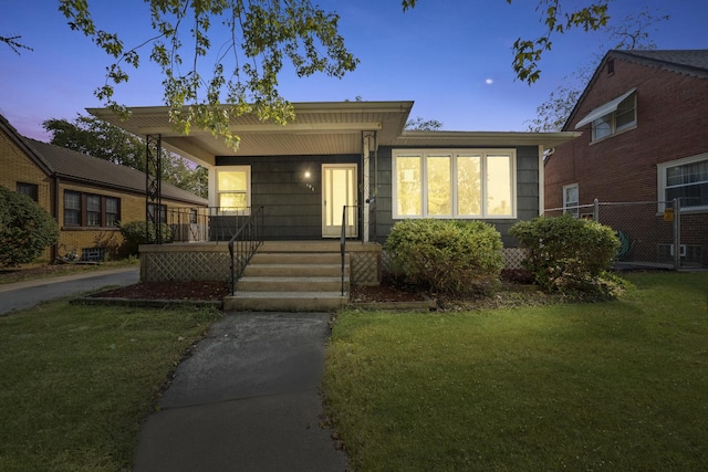 view of front of house with a porch and a lawn