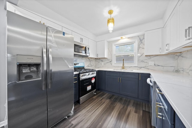 kitchen featuring sink, hanging light fixtures, dark hardwood / wood-style floors, white cabinetry, and stainless steel appliances