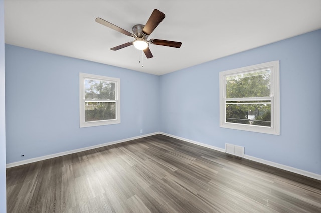 spare room featuring wood-type flooring, ceiling fan, and a healthy amount of sunlight