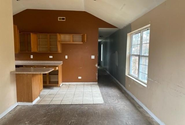 kitchen featuring kitchen peninsula and vaulted ceiling