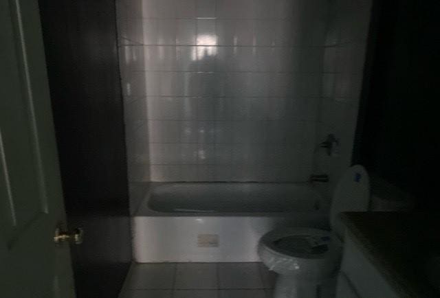 bathroom featuring tile patterned floors, tiled shower / bath combo, and toilet