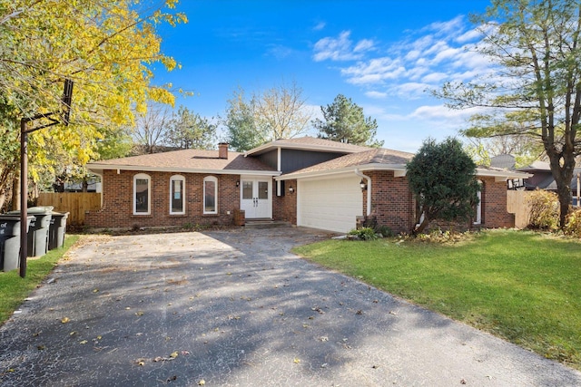 single story home featuring a front lawn and a garage