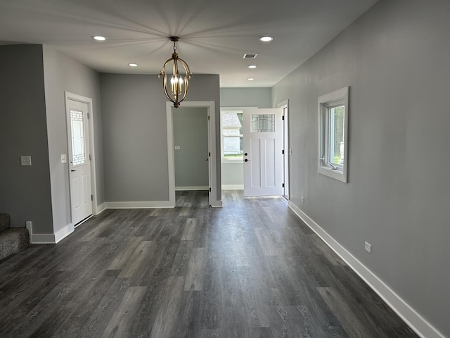 foyer entrance with a notable chandelier and dark hardwood / wood-style flooring