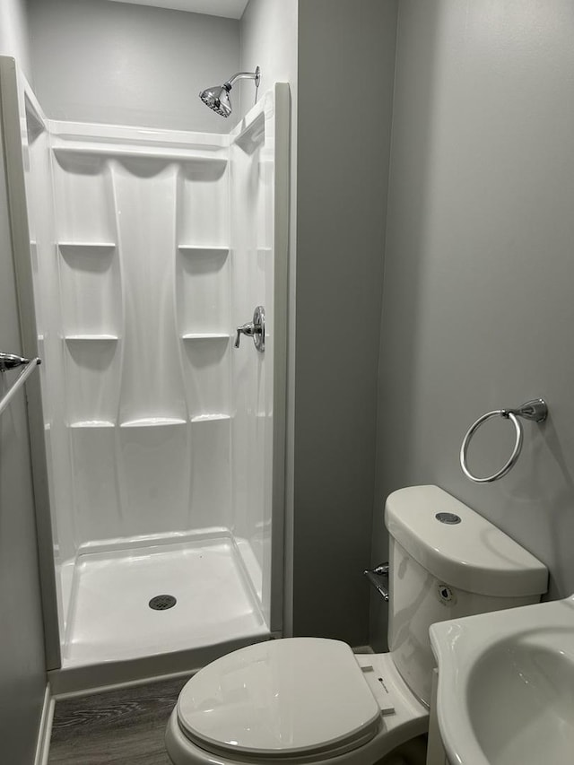 bathroom featuring sink, toilet, walk in shower, and hardwood / wood-style floors