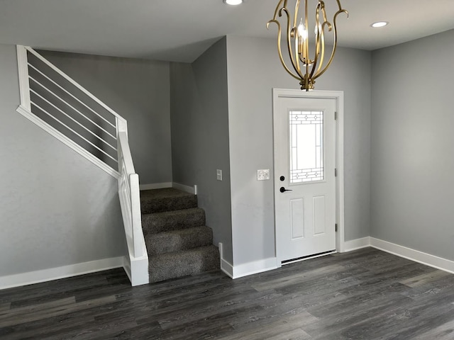 foyer with an inviting chandelier and dark wood-type flooring