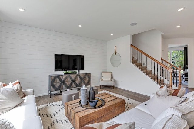 living room with wooden walls and light hardwood / wood-style flooring