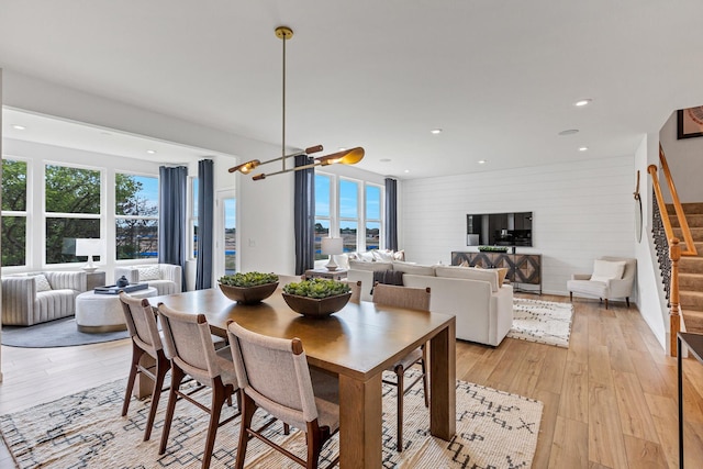 dining space with light hardwood / wood-style floors and an inviting chandelier