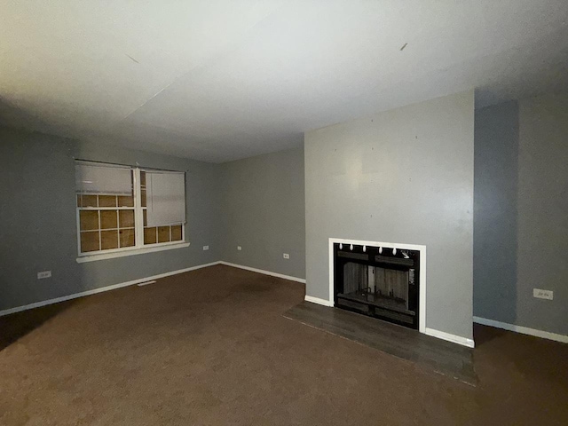 unfurnished living room with dark colored carpet