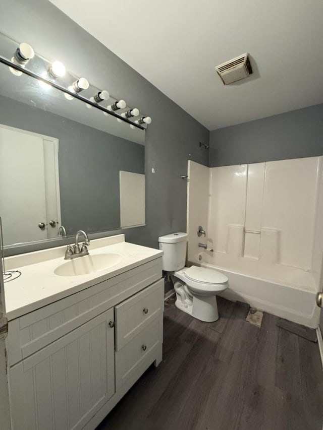 full bathroom with toilet, vanity,  shower combination, and hardwood / wood-style flooring