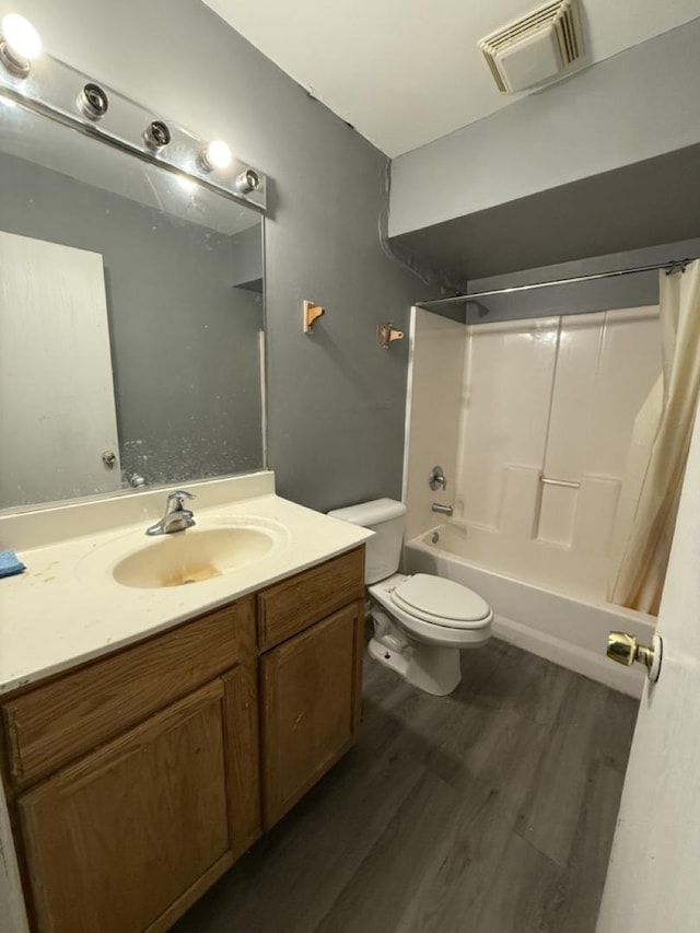 full bathroom with shower / bath combo with shower curtain, hardwood / wood-style floors, vanity, and toilet