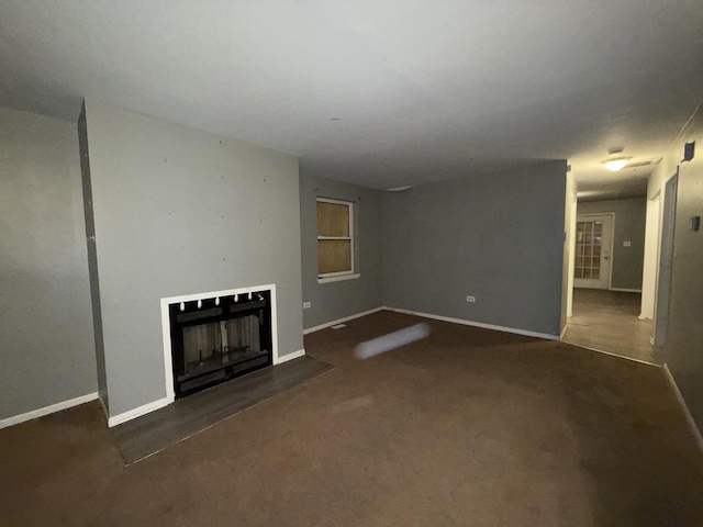 unfurnished living room featuring dark carpet