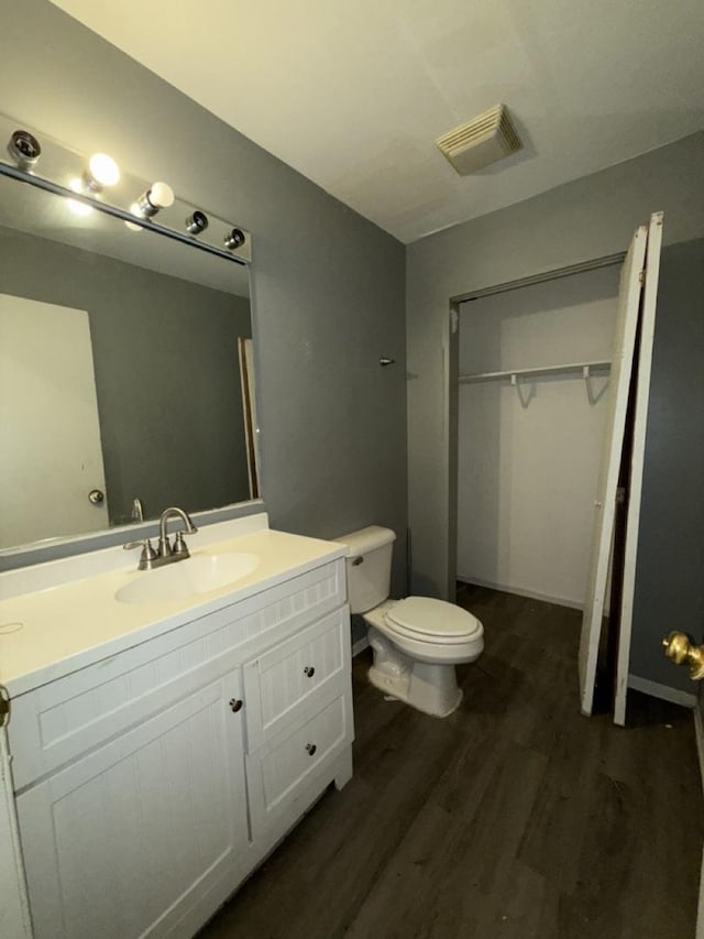 bathroom with toilet, vanity, and hardwood / wood-style flooring