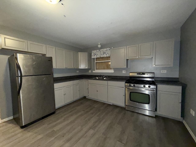 kitchen with sink, white cabinets, wood-type flooring, and appliances with stainless steel finishes