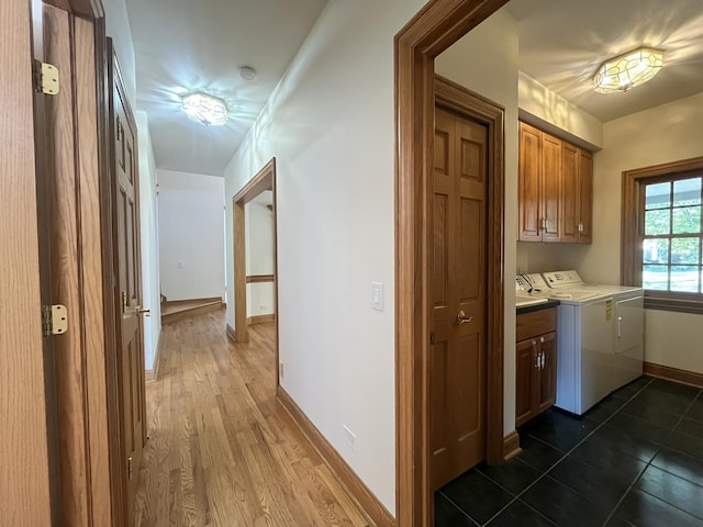 clothes washing area with cabinets, dark hardwood / wood-style flooring, and washer and clothes dryer