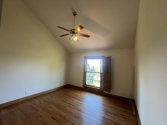 unfurnished room featuring ceiling fan, dark hardwood / wood-style floors, and vaulted ceiling