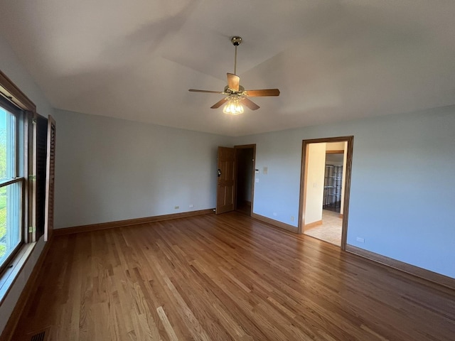 unfurnished room featuring ceiling fan, light hardwood / wood-style floors, and vaulted ceiling