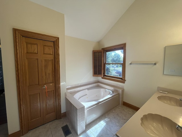 bathroom with tile patterned flooring, vanity, lofted ceiling, and a tub to relax in