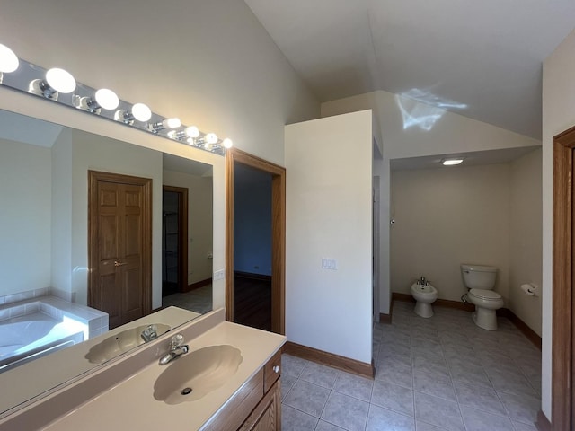 bathroom with vanity, a bidet, tile patterned floors, toilet, and a tub