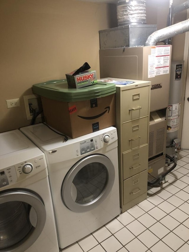 laundry area with gas water heater, separate washer and dryer, and light tile patterned floors