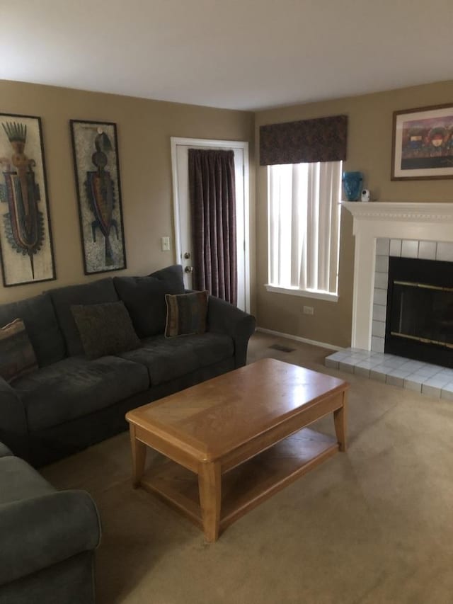 living room with carpet flooring and a tiled fireplace