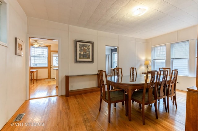 dining room featuring light wood-style flooring and visible vents