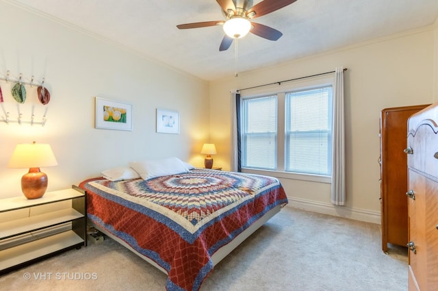 carpeted bedroom featuring ornamental molding, baseboards, and a ceiling fan