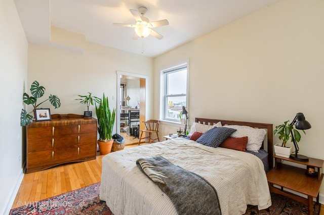 bedroom featuring a ceiling fan, baseboards, and wood finished floors