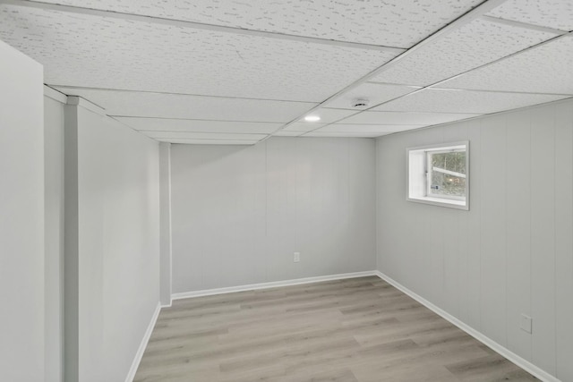 basement with light hardwood / wood-style floors and a drop ceiling