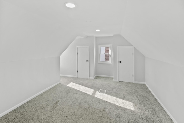 additional living space with light colored carpet and lofted ceiling