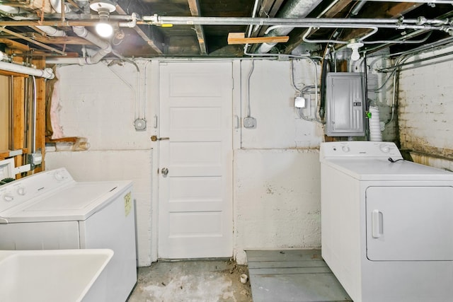 laundry room with electric panel, washer and clothes dryer, and sink