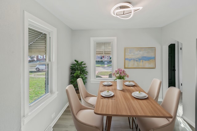 dining space with plenty of natural light and hardwood / wood-style floors