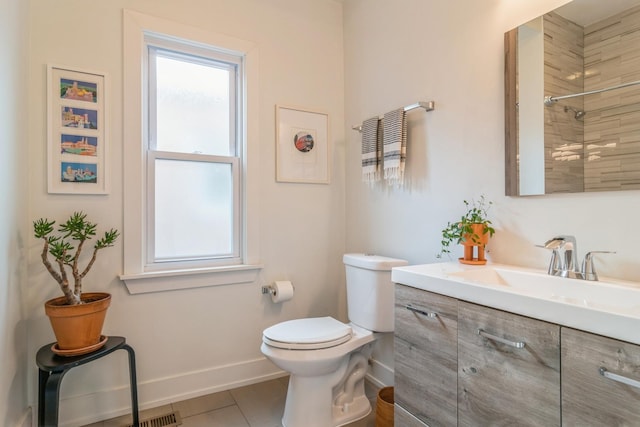 bathroom featuring tile patterned flooring, vanity, toilet, and a tile shower