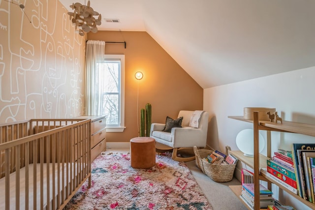 carpeted bedroom featuring vaulted ceiling and a nursery area