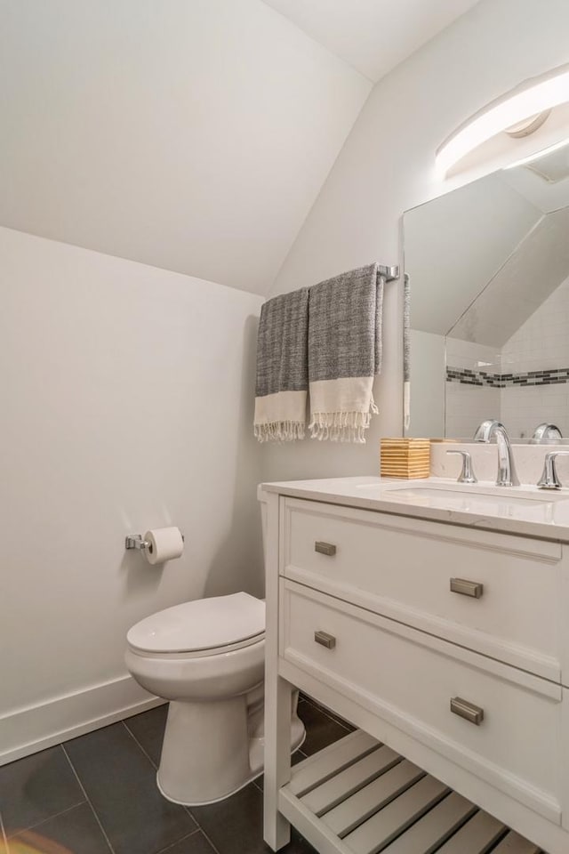 bathroom featuring tile patterned flooring, vanity, vaulted ceiling, and toilet