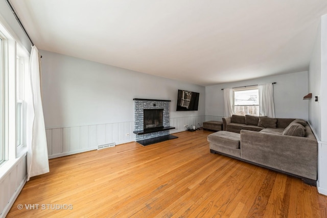 living room featuring light hardwood / wood-style floors and a brick fireplace