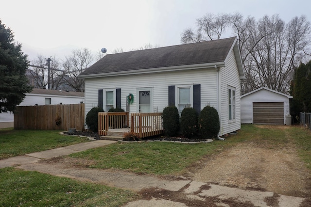 view of front of house featuring a garage, an outdoor structure, and a front lawn