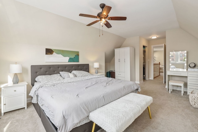 carpeted bedroom with a walk in closet, vaulted ceiling, ceiling fan, connected bathroom, and a closet