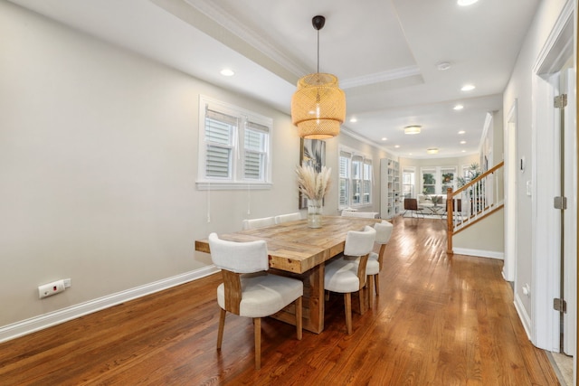 dining room featuring a tray ceiling, dark hardwood / wood-style flooring, and ornamental molding