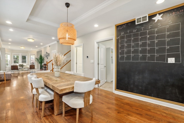 dining space with wood-type flooring and ornamental molding