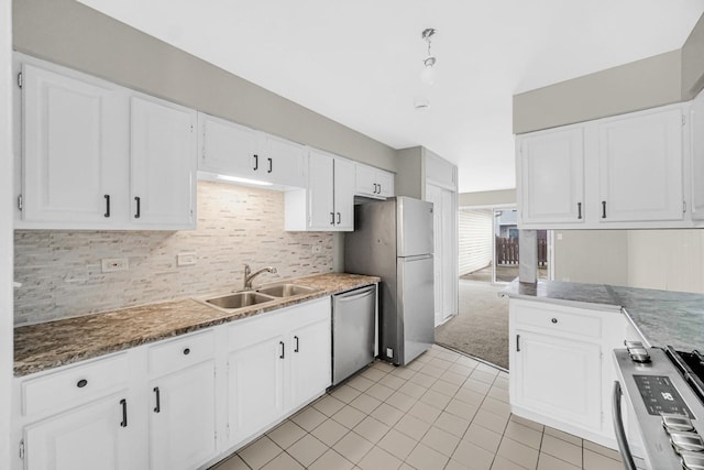 kitchen with backsplash, light carpet, white cabinets, sink, and appliances with stainless steel finishes