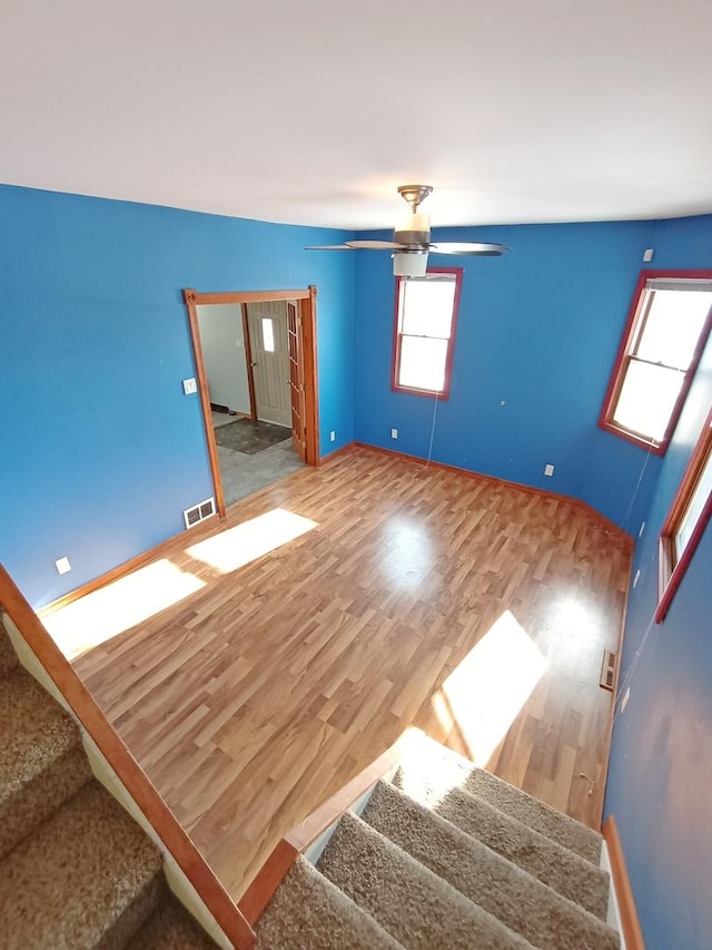 empty room with ceiling fan and wood-type flooring