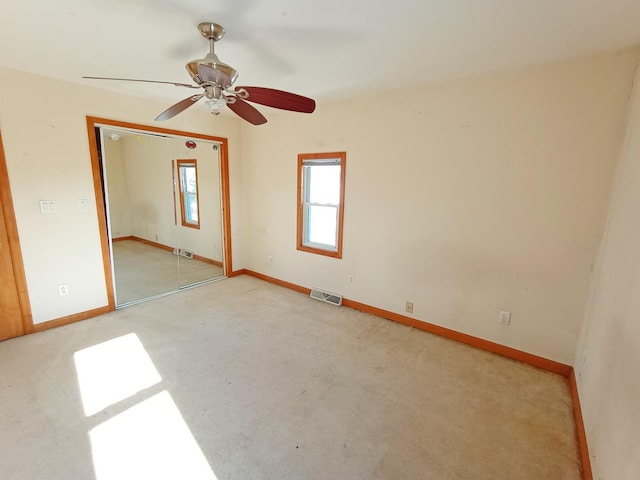 spare room featuring ceiling fan and light colored carpet