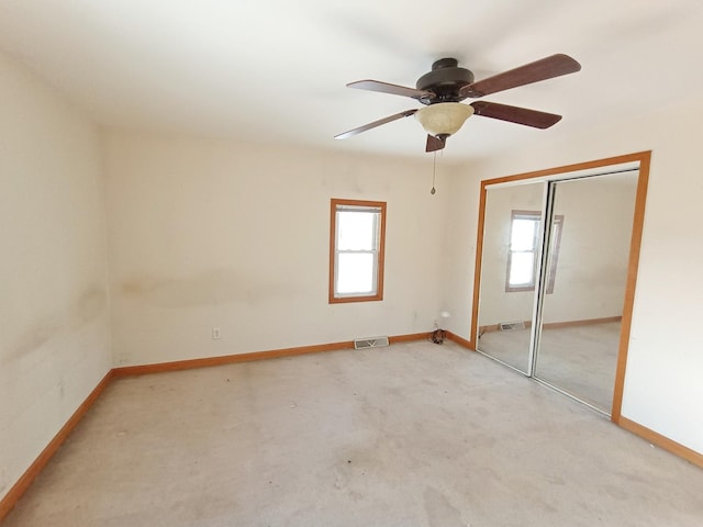 unfurnished bedroom featuring ceiling fan, light carpet, and a closet