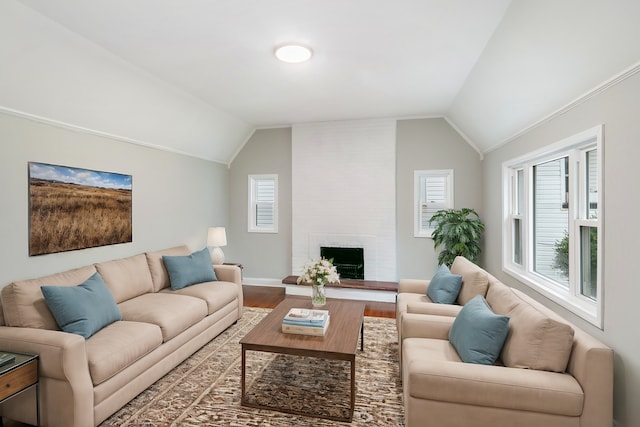 living room with a large fireplace, wood-type flooring, and vaulted ceiling