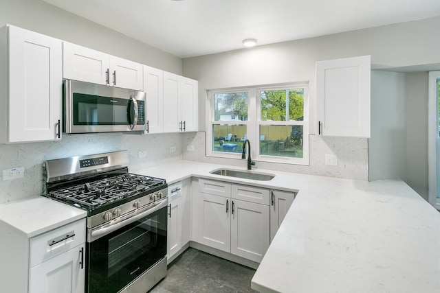 kitchen featuring sink, white cabinetry, stainless steel appliances, and tasteful backsplash