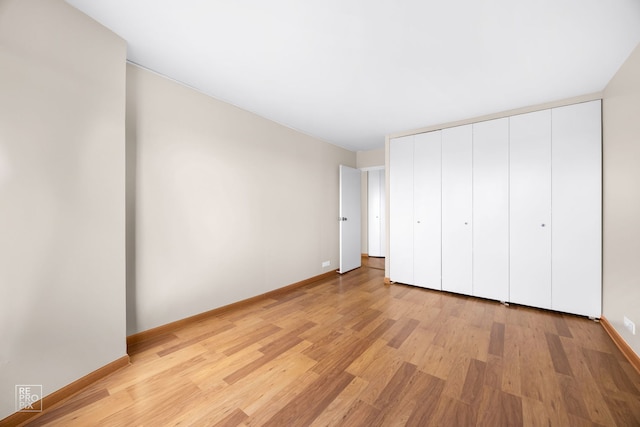 unfurnished bedroom featuring light hardwood / wood-style flooring and a closet