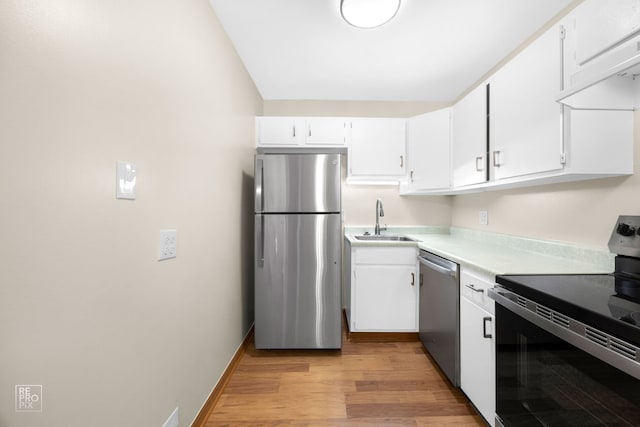 kitchen with sink, white cabinets, light hardwood / wood-style flooring, and appliances with stainless steel finishes